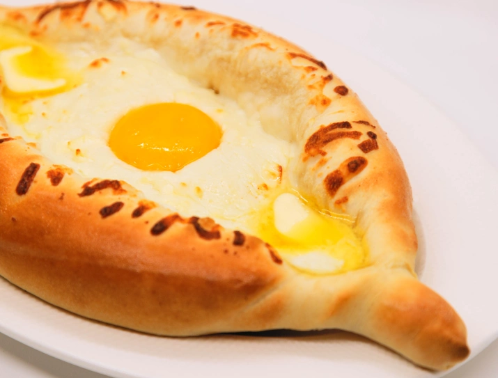 Adjarian khachapuri: boat-shaped cheese bread topped with egg and butter